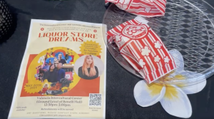 A flyer advertising Liquor Store Dreams sits on a table, with red and white bags of popcorn to the right.